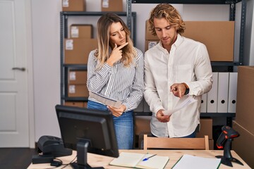 Wall Mural - Man and woman ecommerce business workers reading document at office