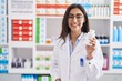 © Krakenimages.com - Young hispanic girl pharmacist holding pills at pharmacy
