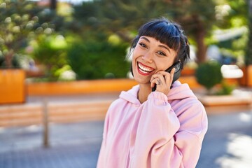 Young woman smiling confident talking on the smartphone at park