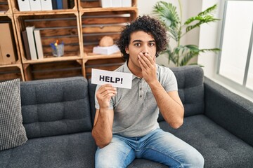 Poster - Hispanic man with curly hair asking for help covering mouth with hand, shocked and afraid for mistake. surprised expression