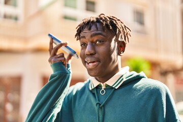 Wall Mural - African american man smiling confident listening audio message by the smartphone at street