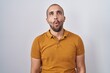 © Krakenimages.com - Hispanic man with beard standing over white background making fish face with lips, crazy and comical gesture. funny expression.