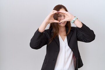 Poster - Beautiful brunette woman wearing business jacket and glasses doing heart shape with hand and fingers smiling looking through sign