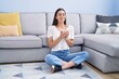 © Krakenimages.com - Young hispanic woman drinking coffee sitting on floor at home