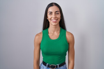 Wall Mural - Young woman standing over isolated background with a happy and cool smile on face. lucky person.