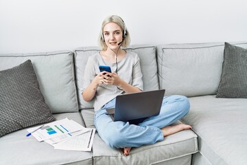 Poster - Young caucasian woman using laptop and smartphone working at home