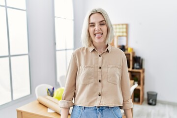 Sticker - Young beautiful caucasian woman at construction office sticking tongue out happy with funny expression. emotion concept.