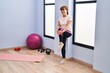 © Krakenimages.com - Middle age woman smiling confident stretching leg at sport center