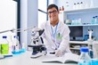 © Krakenimages.com - Down syndrome man wearing scientist uniform using microscope writing on notebook at laboratory