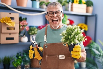 Poster - Hispanic man with grey hair working at florist shop smiling and laughing hard out loud because funny crazy joke.