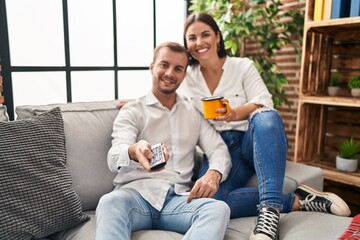 Sticker - Man and woman couple drinking coffee watching tv at home