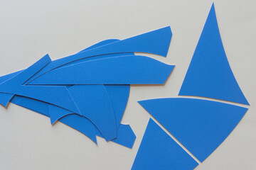 Poster - cut blue paper shapes arranged on blank paper