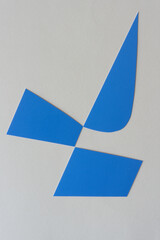 Poster - cut blue paper shapes arranged on blank paper