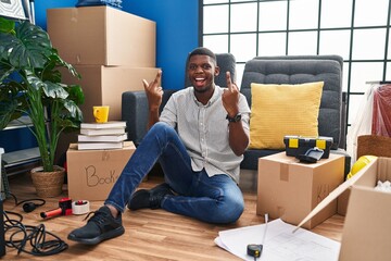 Poster - African american man sitting on the floor at new home showing middle finger doing fuck you bad expression, provocation and rude attitude. screaming excited