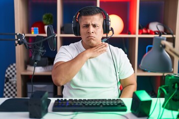 Canvas Print - Young hispanic man playing video games cutting throat with hand as knife, threaten aggression with furious violence