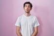 © Krakenimages.com - Young hispanic man standing over pink background looking sleepy and tired, exhausted for fatigue and hangover, lazy eyes in the morning.