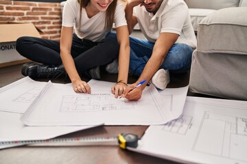 Sticker - Man and woman couple smiling confident looking house plans at new home