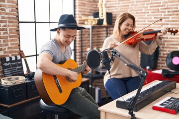 Poster - Man and woman musicians playing violin and classical guitar at music studio