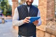 © Krakenimages.com - Young hispanic man smiling confident using touchpad at street