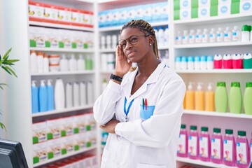 Canvas Print - African american woman pharmacist standing with serious expression at pharmacy