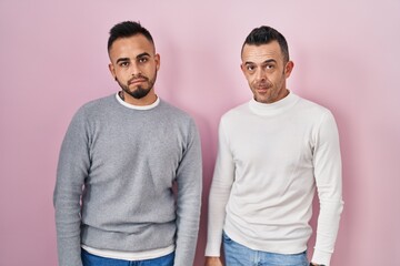 Canvas Print - Homosexual couple standing over pink background looking sleepy and tired, exhausted for fatigue and hangover, lazy eyes in the morning.