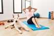 © Krakenimages.com - Young caucasian woman smiling confident training abs exercise with dog at sport center