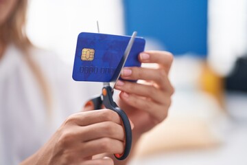 Poster - Young blonde woman cutting credit card at home