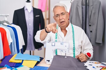 Sticker - Middle age man with grey hair dressmaker using sewing machine pointing displeased and frustrated to the camera, angry and furious with you