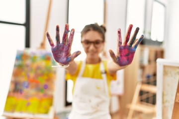 Poster - Adorable girl smiling confident showing painted palm hands at art studio