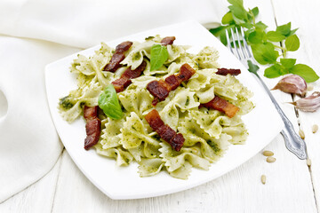 Sticker - Farfalle with pesto and bacon in plate on light board