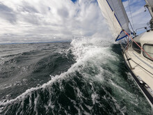 Sailboat Fights Storm And Waves In Open Sea. Concept Of Travel, Adventure, Risk And Adrenaline