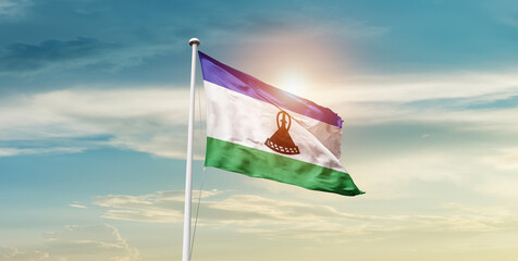 Lesotho national flag cloth fabric waving on the sky - Image