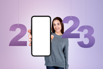 Poster - Young woman smiling showing smartphone with mockup display, 2023