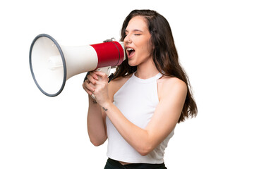 Wall Mural - Young caucasian woman isolated over isolated background shouting through a megaphone