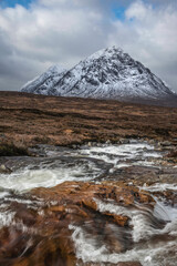 Wall Mural - Majestic Winter landscape image of River Etive in foreground with iconic snowcapped Stob Dearg Buachaille Etive Mor mountain in the background