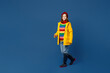 Full body fun young woman wear sweater red hat yellow waterproof raincoat outerwear walking going strolling isolated on plain dark royal navy blue background Outdoors wet fall weather season concept.
