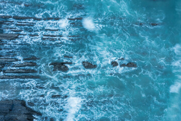 Wall Mural - Aerial drone landscape bird's eye view of vibrant sunset over Welcombe Mouth Beach in Devon England with waves crashing on rocks