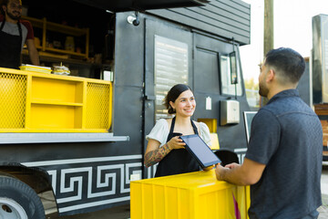 Wall Mural - Woman food trucker talking about the menu to a customer