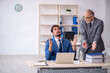 © Elnur - Old male boss and young male employee working in the office