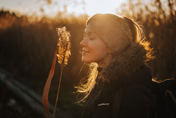 smiling woman in a field with the sunset