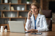 © Prostock-studio - Worried Doctor Woman Using Laptop And Talking On Cellphone At Workplace