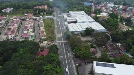 Canvas Print - Aerial of a city with a busy highway, dense buildings and trees