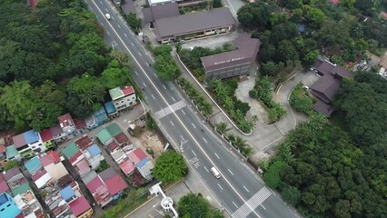 Canvas Print - Aerial of a city with a busy highway, dense buildings and trees