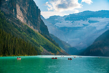 Lake Louise In The Afternoon Of A Summer Day. Green Water And Sun Setting Behind The Mountains.