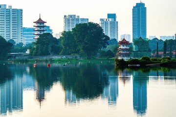 Poster - Beautiful view of the 7-Storey Pagoda and skyscrapers reflecting on water in Singapore at sunset