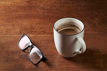 Canvas Print - Brewed milk coffee and reading glasses