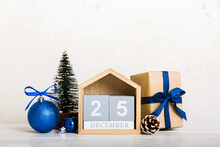25 December. Christmas Composition On Colored Background With A Wooden Calendar, With A Gift Box, Toys, Bauble Copy Space