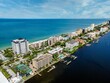 Drone shot of a cityscape view of a residential Peninsula with blue water and blue cloudy sky