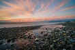 Scenic shot of the Hokitika beach in New Zealand at sunset with pebbles on the coast