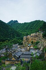 Poster - Village Cuandixia with residential houses surrounded by high hills covered with lush green trees